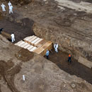 Photo: Workers in full Hazmat suits bury rows of coffins in New York's Hart Island mass grave