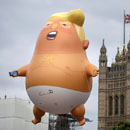 Photo: Knife-wielding cultist defends Trump's honor by stabbing giant Trump balloon in the diaper